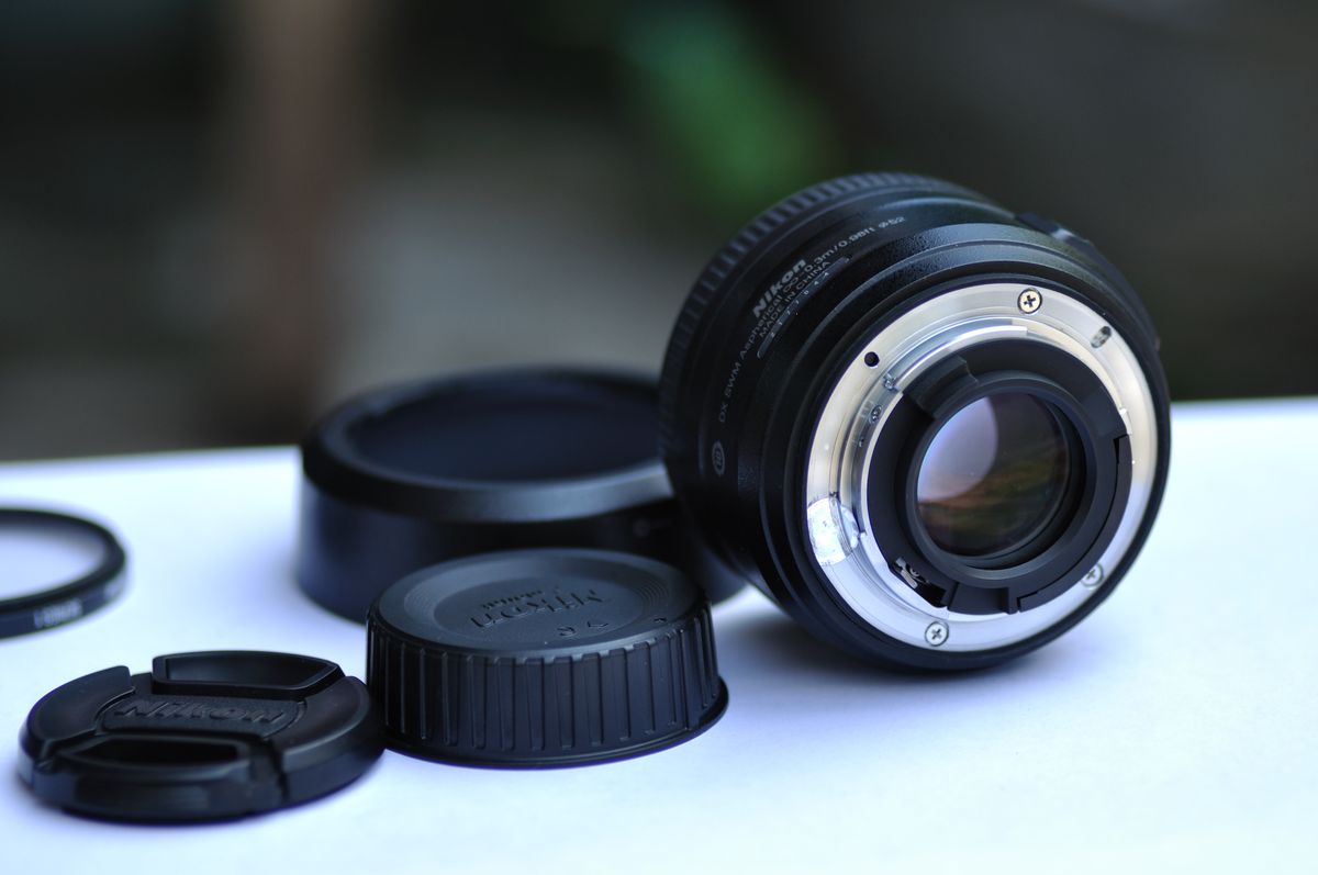 Camera lens with lens caps and a filter on a desk, representing careers in media production